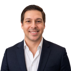 Smiling man in a navy suit and white shirt posing for a professional headshot.